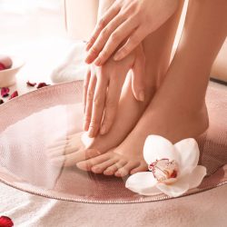 Young woman undergoing spa pedicure treatment in beauty salon